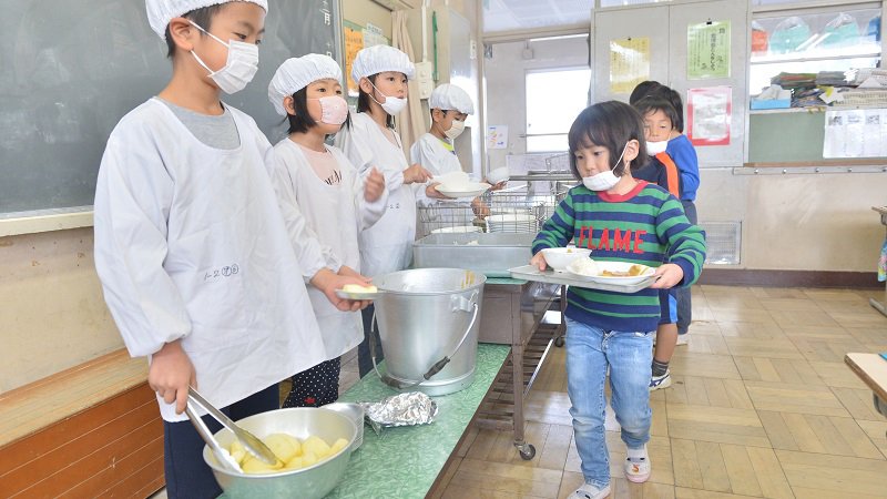 中午一到，由各班級學生將裝滿營養午餐的餐車推回班上，開始替同學一一分裝打菜。黃建賓攝